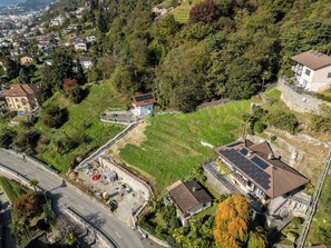 A residential area with houses, a road, and a construction site. - Your Elegant  Mountain Retreat 1103 (Ticino)