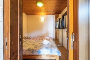 Ein Schlafzimmer mit Bett, Kleiderschrank und einer kleinen Küchenzeile.