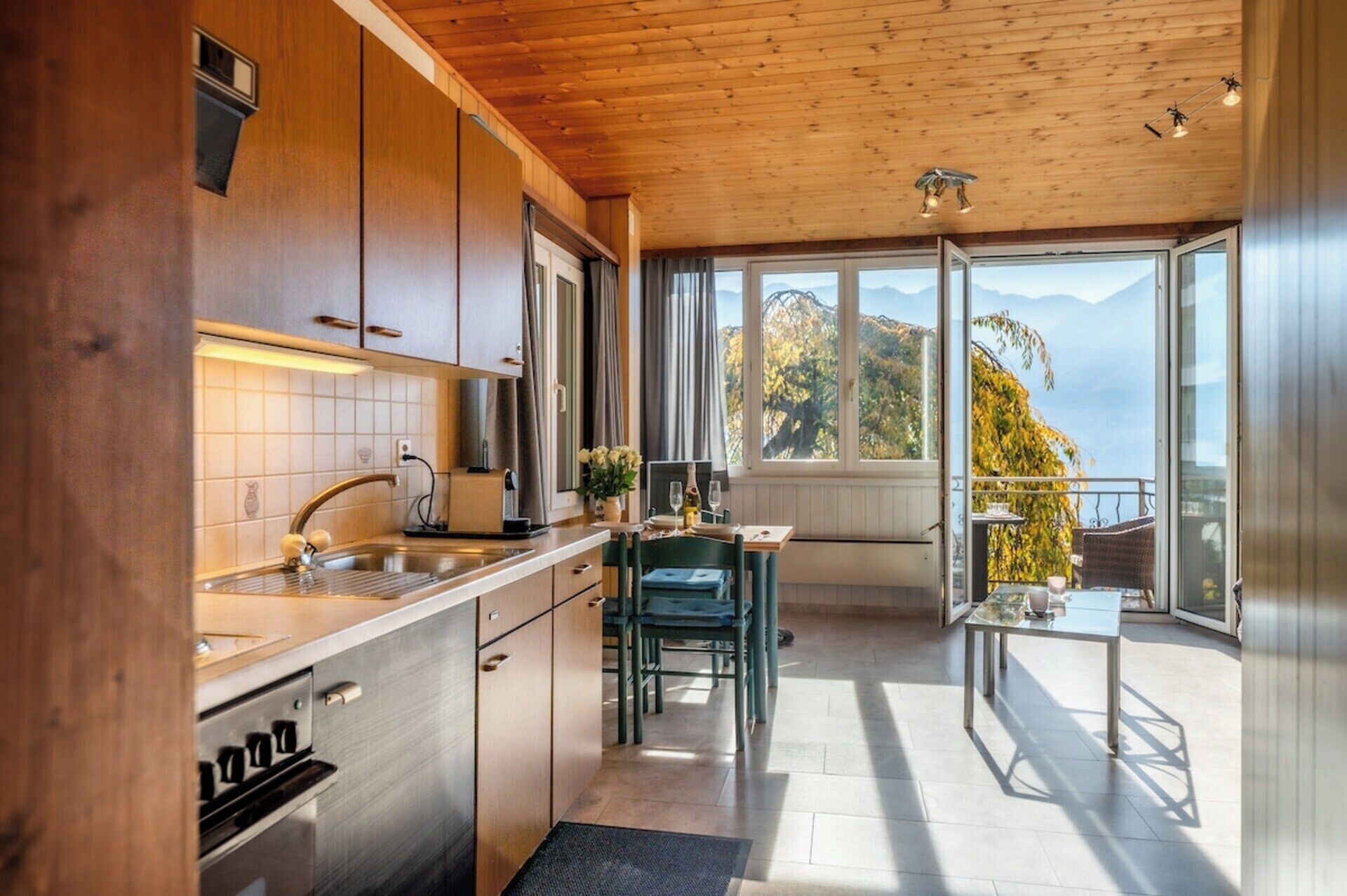 Eine moderne Küche mit Blick auf Berge durch große Fenster.
