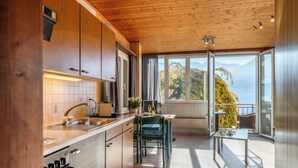 Uma cozinha moderna com vista para montanhas através de grandes janelas.