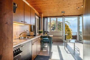 Eine moderne Küche mit Blick auf Berge durch große Fenster.