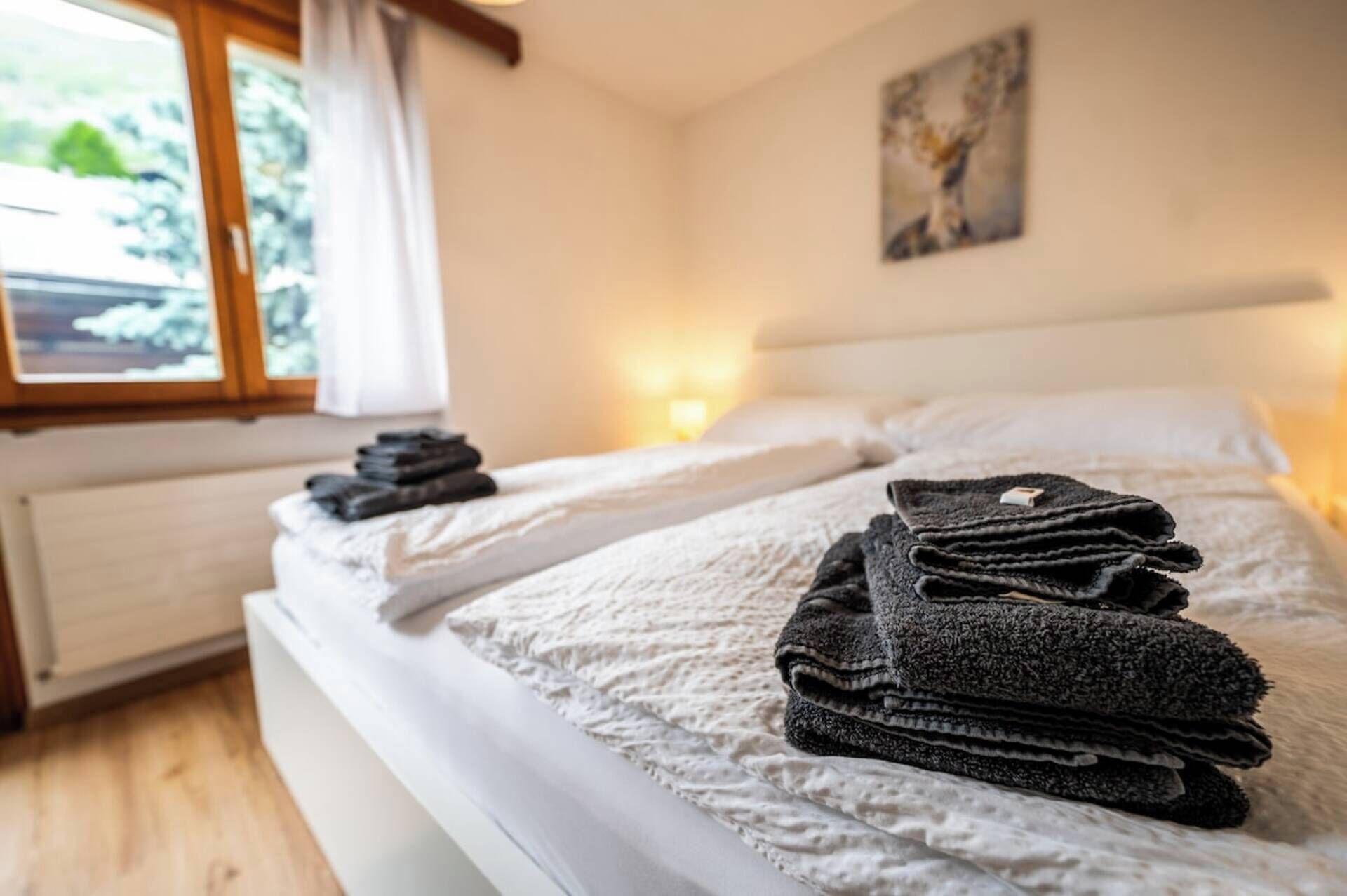 Une chambre d’hôtel avec un lit, une fenêtre et un tableau au mur.