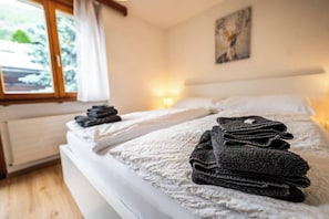 Ein Hotelzimmer mit einem Bett, einem Fenster und einem Bild an der Wand.