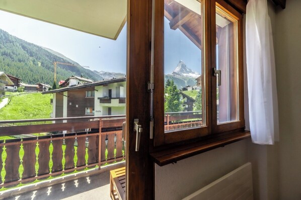 Ein Balkon mit Blick auf einen Berg und Häuser.