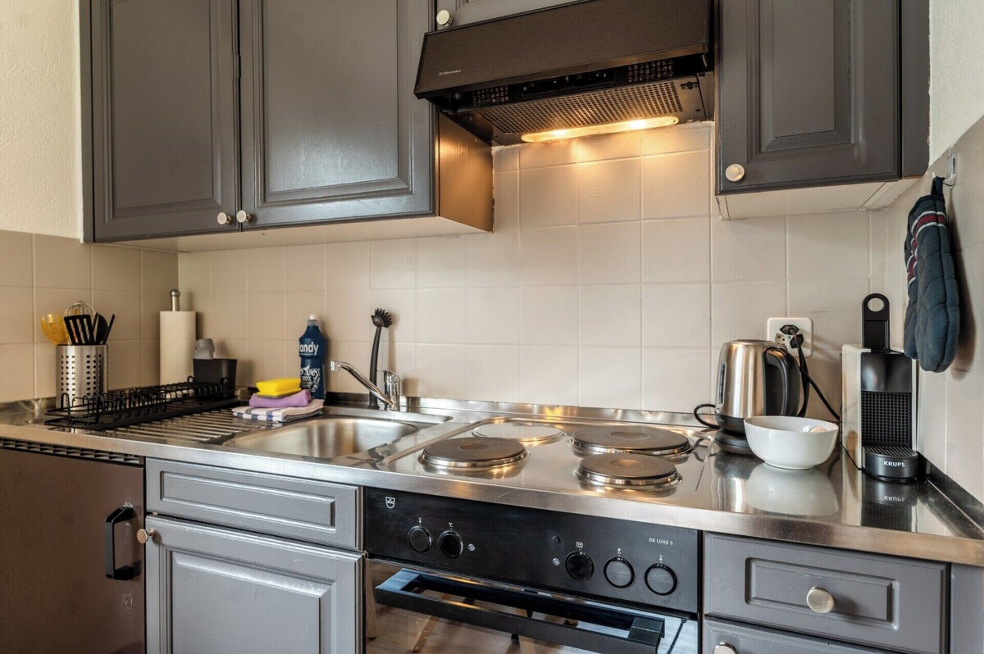 Eine moderne Küche mit Edelstahlgeräten, einer doppelten Spüle und einem eingebauten Backofen.