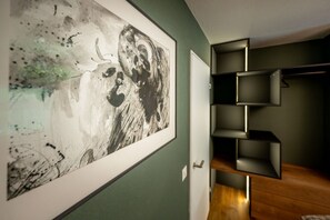 A room with a large abstract painting on the wall, a wooden floor, and a built-in shelving unit. - Alpine Elegance with Matterhorn Views 1083 (Wallis)