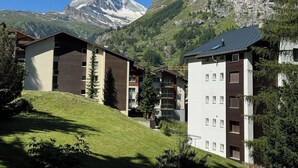 A modern hotel with a mountain view, featuring a prominent mountain peak in the background. - Alpine Elegance with Matterhorn Views 1083 (Wallis)