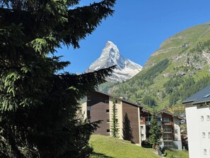 Un bâtiment avec vue sur la montagne, probablement un hôtel ou un complexe touristique, avec un sommet montagneux bien visible en arrière-plan.