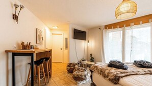 A bedroom with a bed, a desk with chairs, a TV, and a window with curtains. - Wake to the Matterhorn in Luxury 1084 (Wallis)