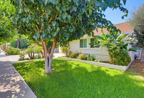 A residential property with a well-maintained lawn, a mature tree, and a house with a red-tiled roof. - Welcome to Casa Limón, a quiet, spacious home in Lake Balboa. (Los Angeles)