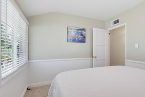 A bedroom with a bed, a window with blinds, a door, and a wall-mounted painting. - Welcome to Casa Limón, a quiet, spacious home in Lake Balboa. (Los Angeles)