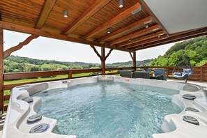 A hot tub with a wooden deck and a view of a green landscape. - Spacious villa in Zagorje with jacuzzi, sauna, pool, barbecue, and scenic views (Pregrada)