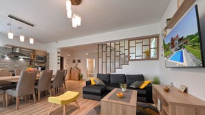 A modern living room with a sofa, chairs, a coffee table, and a dining area with a table and chairs. - Spacious villa in Zagorje with jacuzzi, sauna, pool, barbecue, and scenic views (Pregrada)