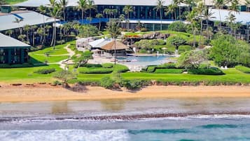 Un resort con varias construcciones, acceso directo a la playa y una zona de piscina.