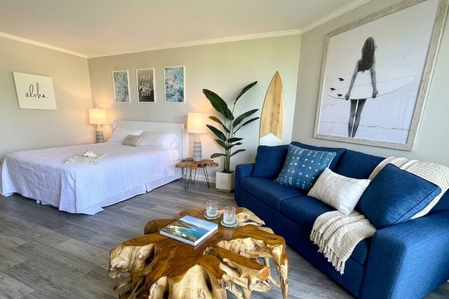 Ein Hotelzimmer mit einem Bett, einer Couch, einem Couchtisch und einer großen Pflanze.