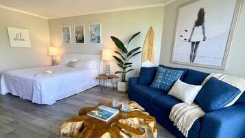 Ein Hotelzimmer mit einem Bett, einer Couch, einem Couchtisch und einer großen Pflanze.