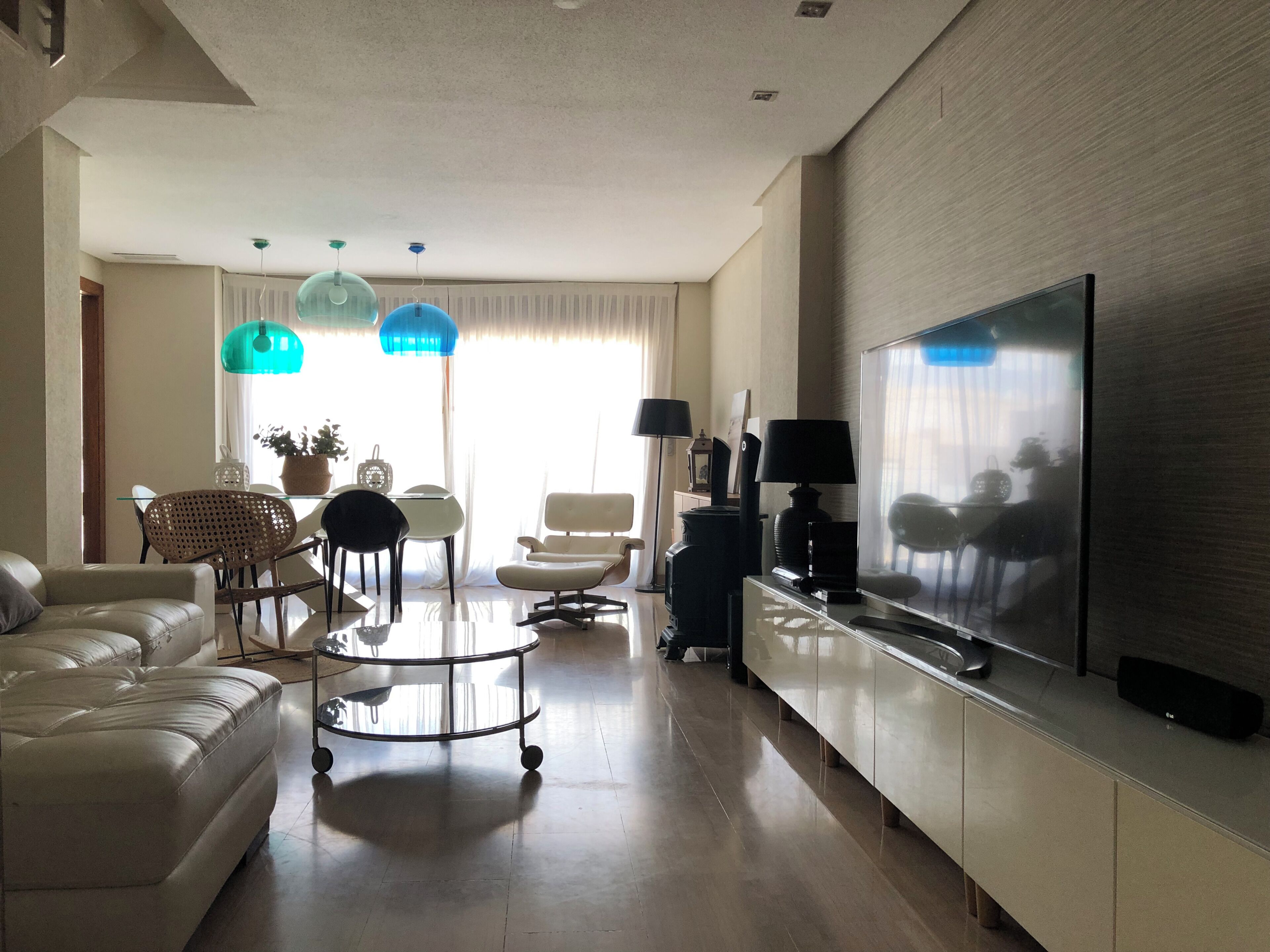 Un salon moderne avec un canapé, une table basse et un téléviseur.