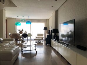 A modern living room with a sofa, a coffee table, and a TV.