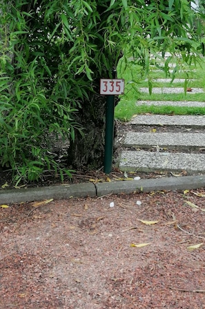 A street sign with the number 335, a sidewalk, and a grassy area with a tree. - Ein Bungalow in einem Ferienpark, ganz in der Nähe vom Meer by Interhome (Middelkerke)
