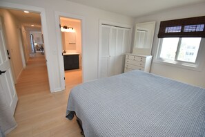 A bedroom with a bed, a dresser, a mirror, a window with blinds, and a walk-in closet. - Maritime Place B9 - Oceanfront in Garden City Beach (Garden City)
