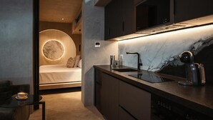 Una cocina moderna con horno empotrado, lavabo y cafetera.