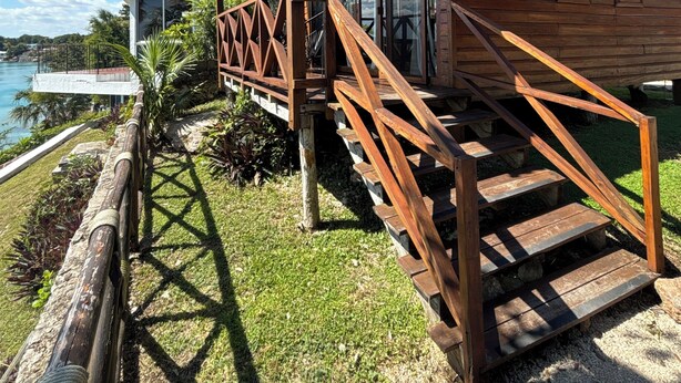 Un edificio de madera con balcón y una escalera que lleva a una terraza.