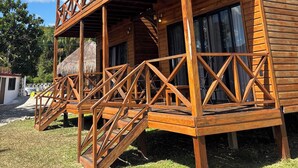 Un bâtiment en bois doté d’un balcon, d’un escalier et d’une toiture en chaume.