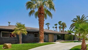 A modern house with a paved driveway, palm trees, and a well-maintained lawn. - Speakeasy Bar, Pool, Hot Tub | 4BD, Palm Springs | Sleeps 8, Private Patios, Poker Table (Palm Springs)