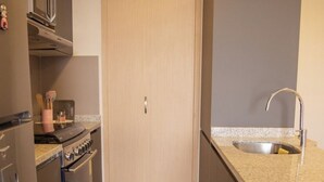 Une cuisine dotée d’une porte en bois, d’appareils électroménagers en acier inoxydable et d’un plan de travail en granit.