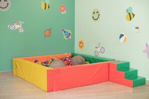 A play area with a soft play mat, colorful balls, and a small slide. - Elegant 2-Bedroom Condo in Colomos, Providencia (Guadalajara)