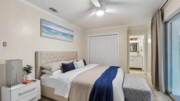 A bedroom with a bed, bedside table, and a ceiling fan.