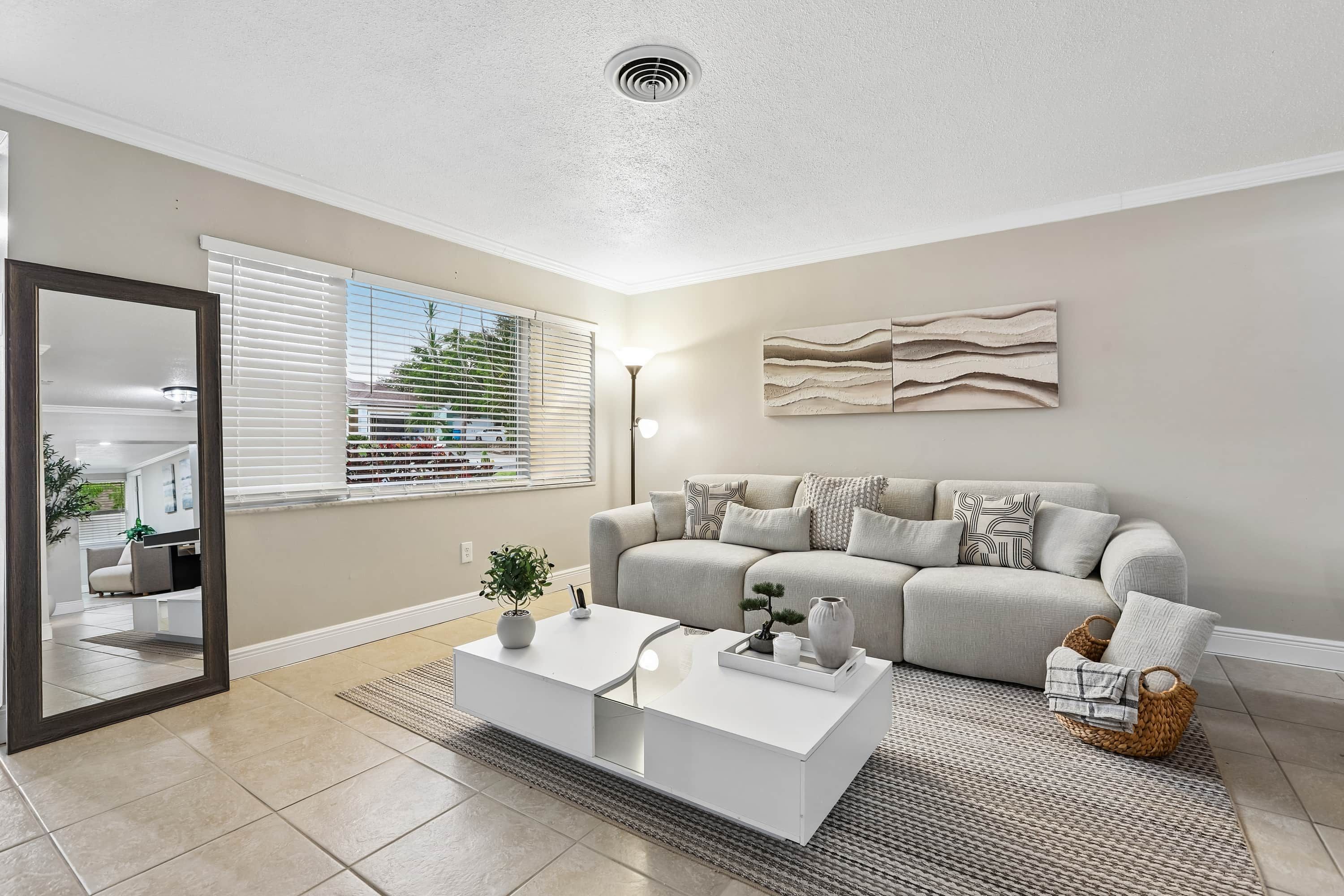 A modern living room with a sofa, coffee table, and a painting on the wall.