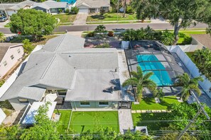 Ein Wohnhaus mit großem Schwimmbad, gepflegtem Rasen und Garage.