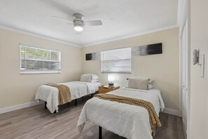 A bedroom with two beds, a ceiling fan, and two windows with blinds. - Resort Pool Home • 3 Min to Beach • Pool Table (Pinellas County)