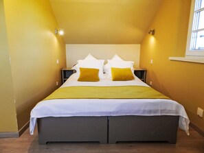 Um quarto com uma cama, duas mesas de cabeceira e uma janela.