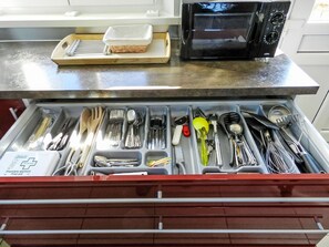 A kitchen drawer with utensils and a microwave above it. - Gîte La Grenouillère by Interhome (Esquéhéries)