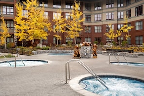A hotel courtyard with multiple hot tubs, a stone fountain, and autumn trees. - Marriott Timber Lodge - Premier Resort 2 Bedroom Villa condo at Heavenly gondola (South Lake Tahoe)