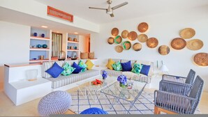 A modern living room with a sofa set, a coffee table, and a wall adorned with woven baskets. - Condo Terramar 4BD - Terrazas Punta Mita (Punta de Mita)