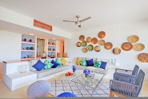 A modern living room with a sofa set, a coffee table, and a wall adorned with woven baskets. - Condo Terramar 4BD - Terrazas Punta Mita (Punta de Mita)