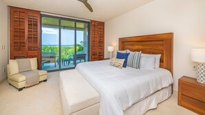 A bedroom with a large bed, a ceiling fan, a sofa, and a view of a balcony. - Condo Balboa 3BD - Tau Punta Mita (Punta de Mita)