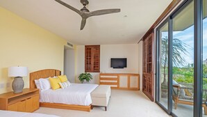 A bedroom with a bed, bedside table, lamp, TV, and a view of the outdoors. - Condo Balboa 3BD - Tau Punta Mita (Punta de Mita)