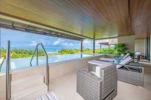 A rooftop infinity pool with a view of the ocean, outdoor seating area with wicker furniture, and a wooden ceiling structure. - Condo Balboa 3BD - Tau Punta Mita (Punta de Mita)