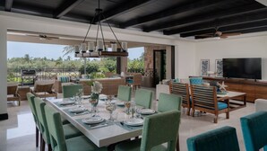 A spacious outdoor dining area with a long table set for multiple people, surrounded by comfortable seating. - Condo Azalea 4BD - Hacienda De Mita (Punta de Mita)
