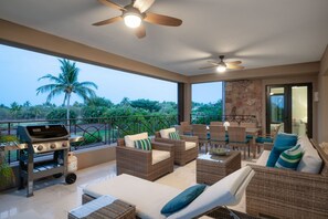 An outdoor patio with wicker furniture, a barbecue grill, and a view of palm trees. - Condo Azalea 4BD - Hacienda De Mita (Punta de Mita)