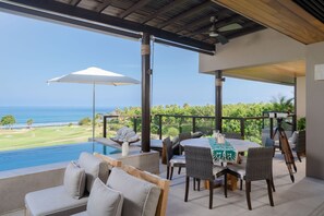 A poolside area with a view of the ocean, a table with chairs, and a telescope. - Condo Piscis 3BD - Marietas Punta Mita (Punta de Mita)