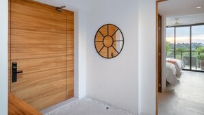 Ein modernes Interieur mit einer Holztür zum Verschieben, einer runden Wanddekoration und Blick auf einen Balkon mit einem Bett.
