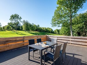 An outdoor deck with a table and chairs, overlooking a grassy area with trees. - "Alkmar" - 6.5km from the sea by Interhome (Ørum Djurs)