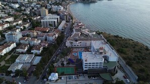 Une vue aérienne d’une ville côtière, avec ses bâtiments, sa plage et une route.