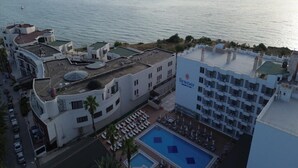 A hotel with a rooftop pool, a beach view, and a sign for 'NEWDAY.' - Ada Newday Resort Hotel & Spa (Kuşadası)