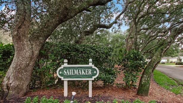 A sign with the name 'SAULMAKER' in a lush, green setting with trees and shrubs. - Sailmaker Gated Complex: Near Pool & Beach (Fernandina Beach)